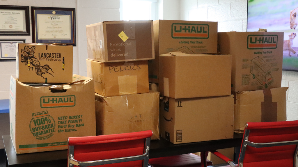 Boxes of donated school supplies stacked on a table.