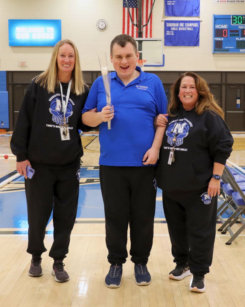 Student and two coaches pose for photo during senior announcements.