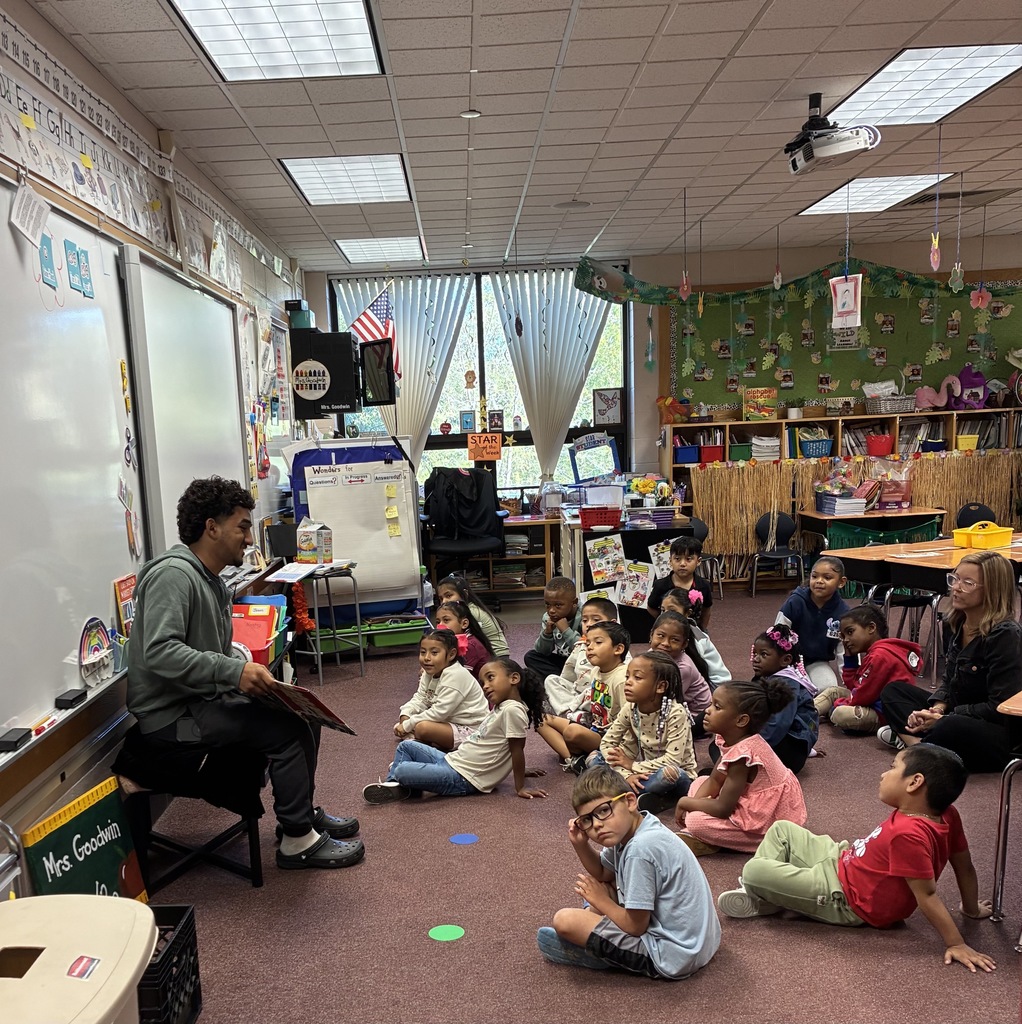 A high school student is reading to a class of kindergarteners