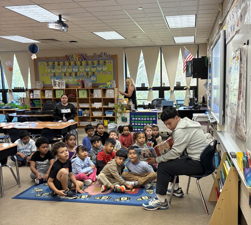 'A high school student is reading to a class of kindergarteners