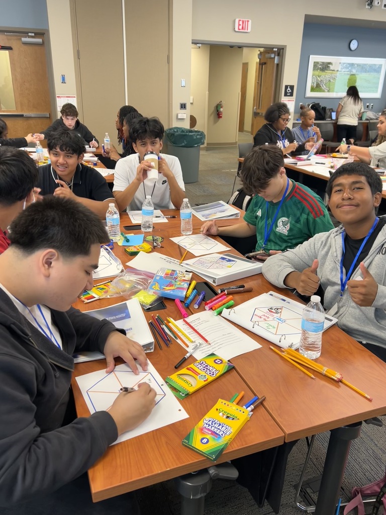Six students are working at a table at the MCIU