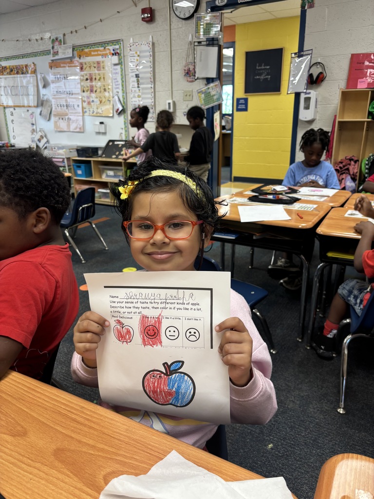 Student showing their apple artwork