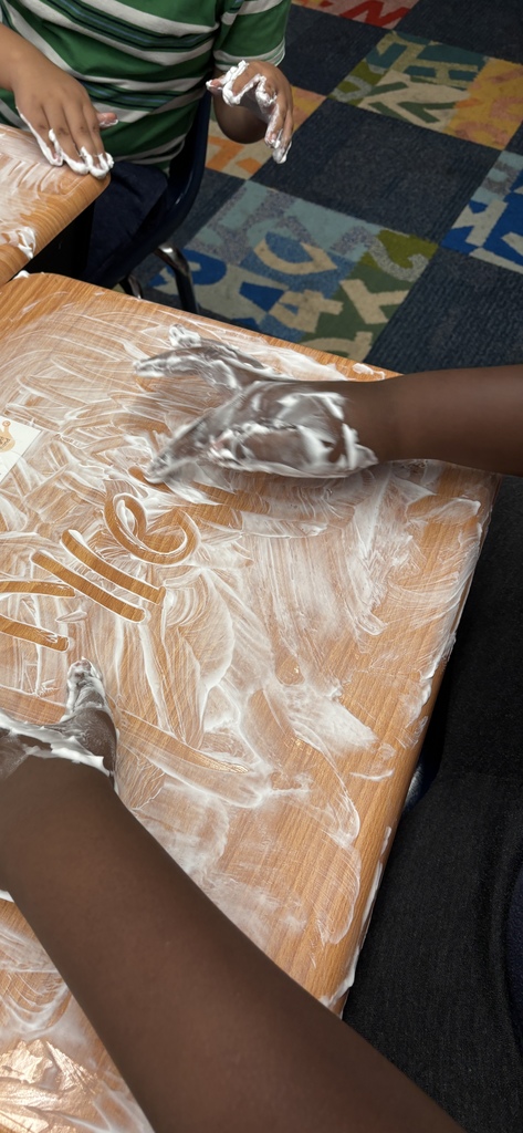 Students writing words in shaving cream for a sensory twist.