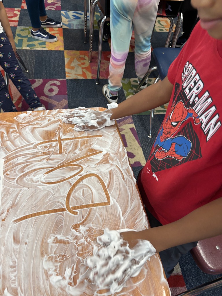 Students writing words in shaving cream for a sensory twist.