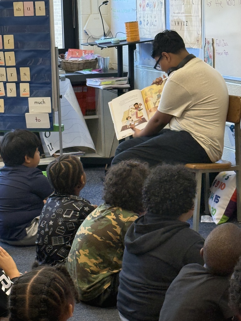 A student from NAHS reads a book to first grade students.