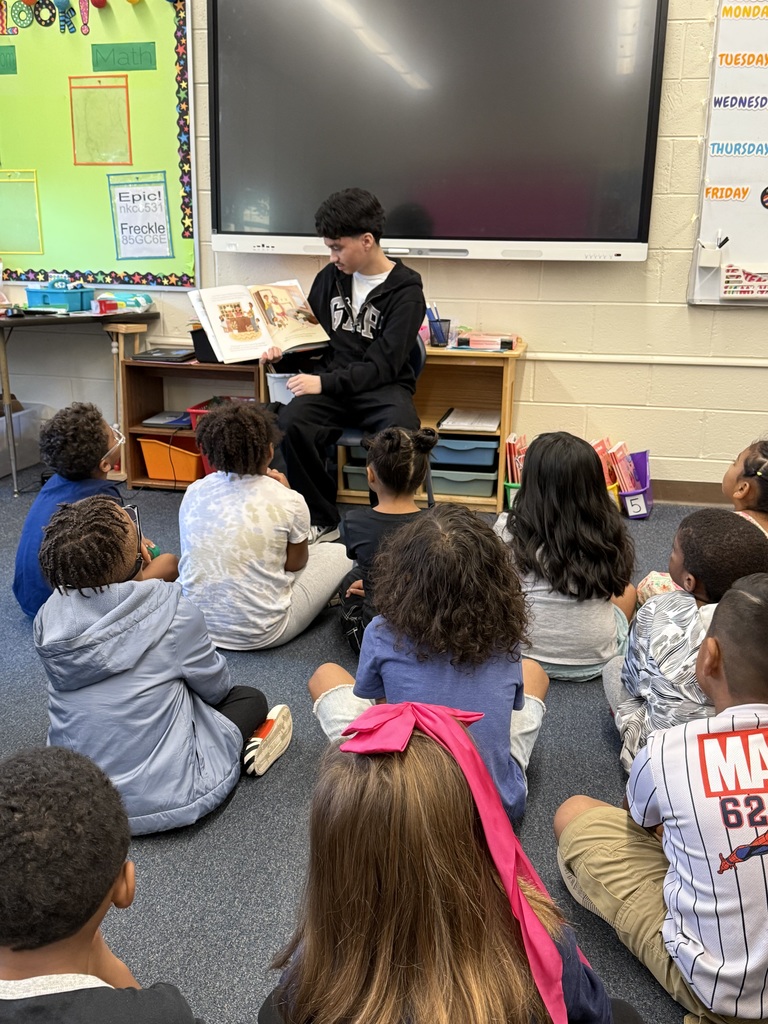 A student from NAHS reads a book to first grade students.