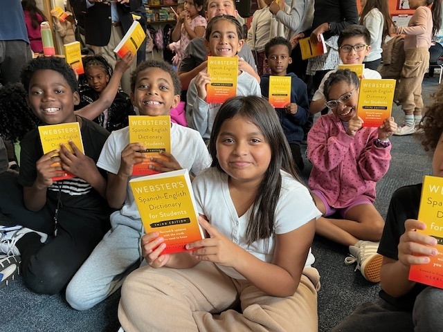 Third grade students holding up their Spanish-English Dictionaries from the Rotary Club. 