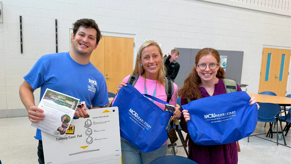 NASD teachers holding up items they received from community partners.