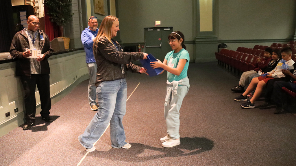 Student receiving gift bag for perfect attendance.
