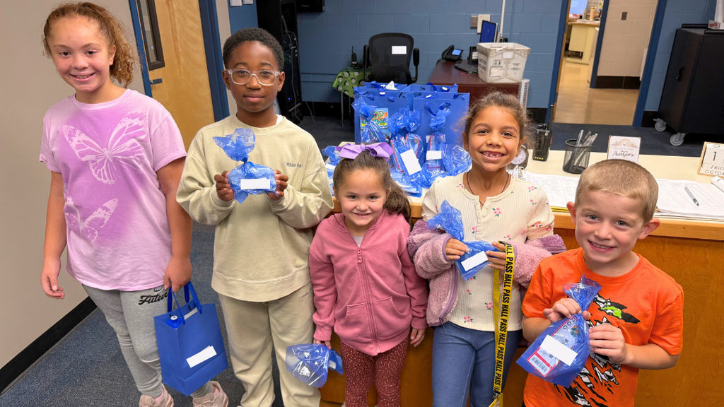 Five students holding up their prizes for a photo.