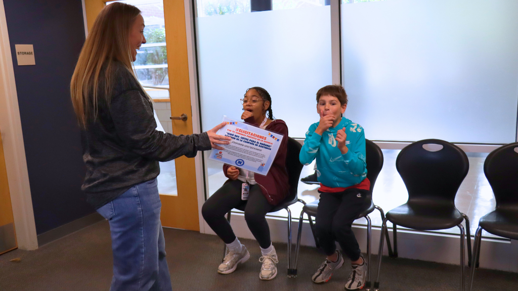 Two students finding out they just won bikes for having perfect attendance for the start of school.