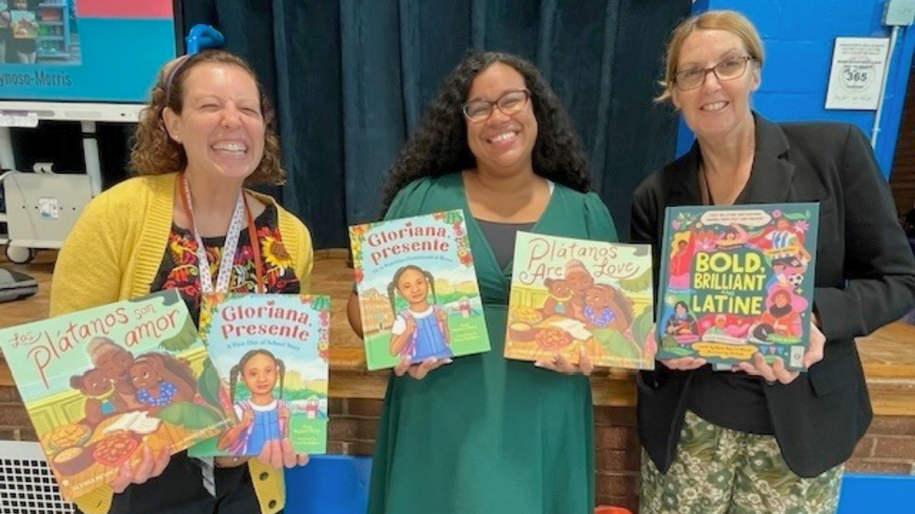 Cole Manor staff poses with visiting author holding up books.