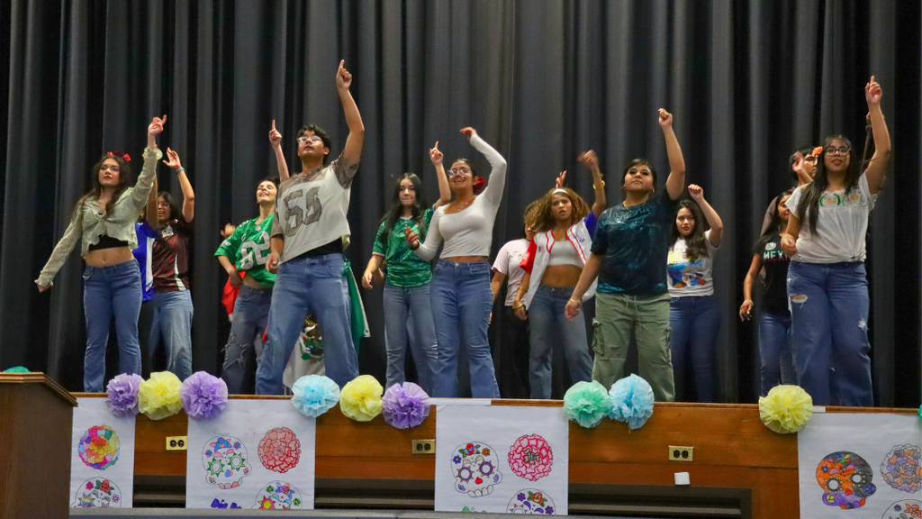 Students from Sabor Latino club performing on stage.