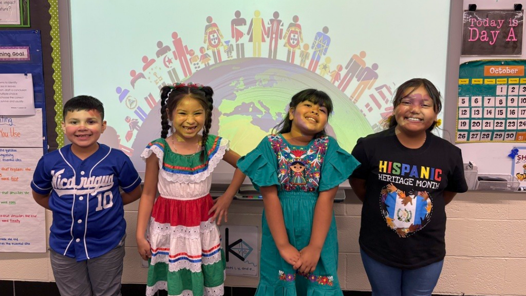 Four students in cultural attire posing for a photo.
