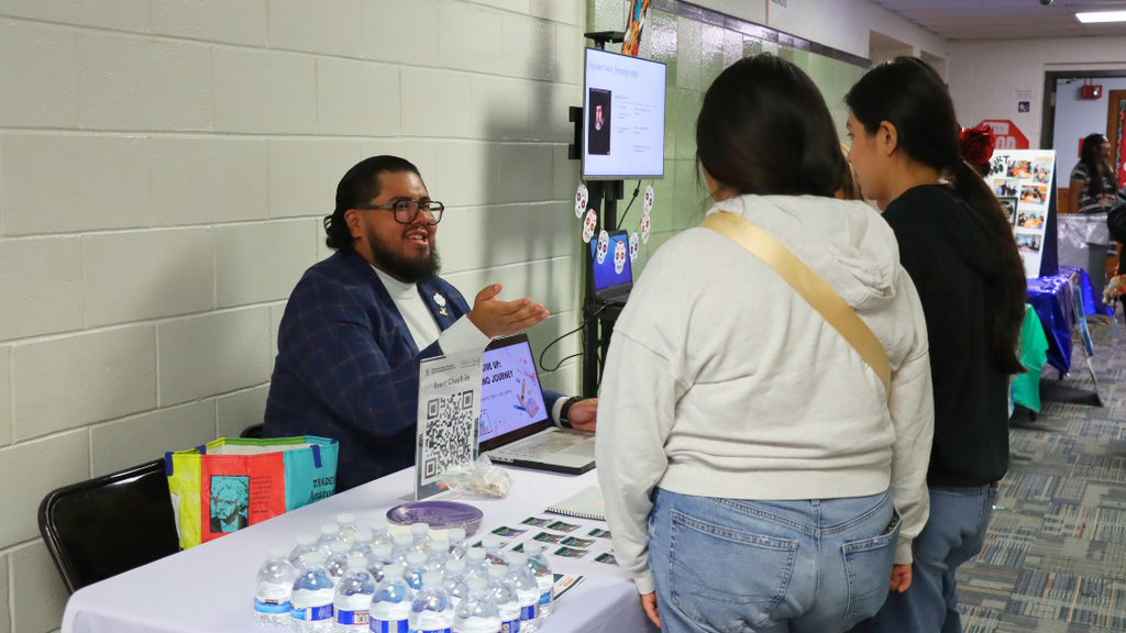 Community partner sitting at a table speaking to students.