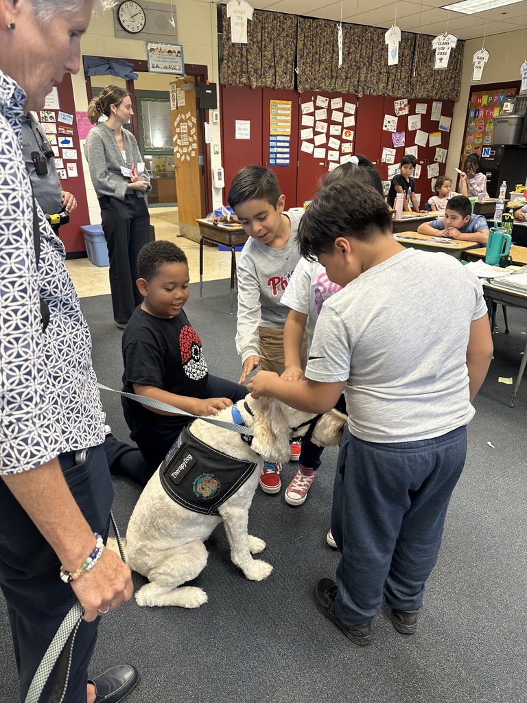 Students pet Nutmeg the dog.