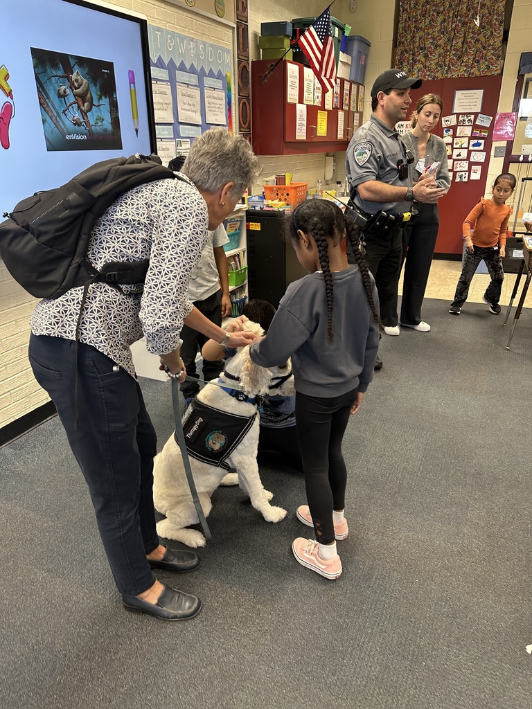 Students pet Nutmeg the dog.