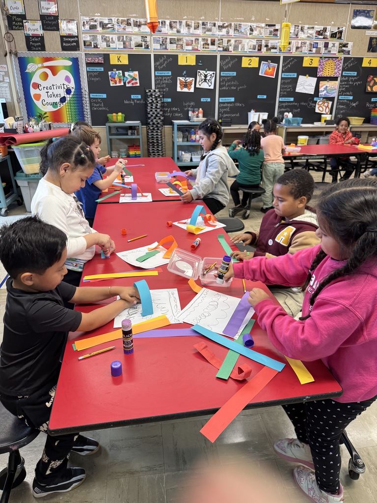 Kindergartners create rainbow paper line sculptures in art class.