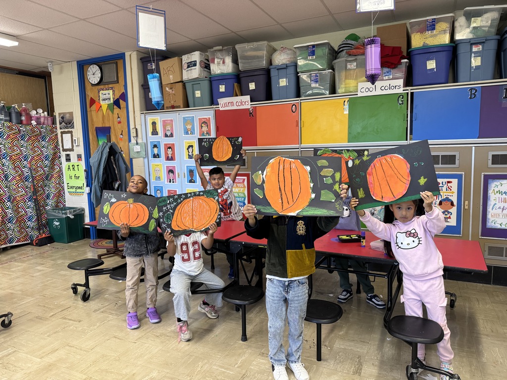 First graders show their pumpkin art.