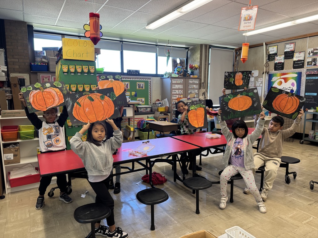 First graders show their pumpkin art.