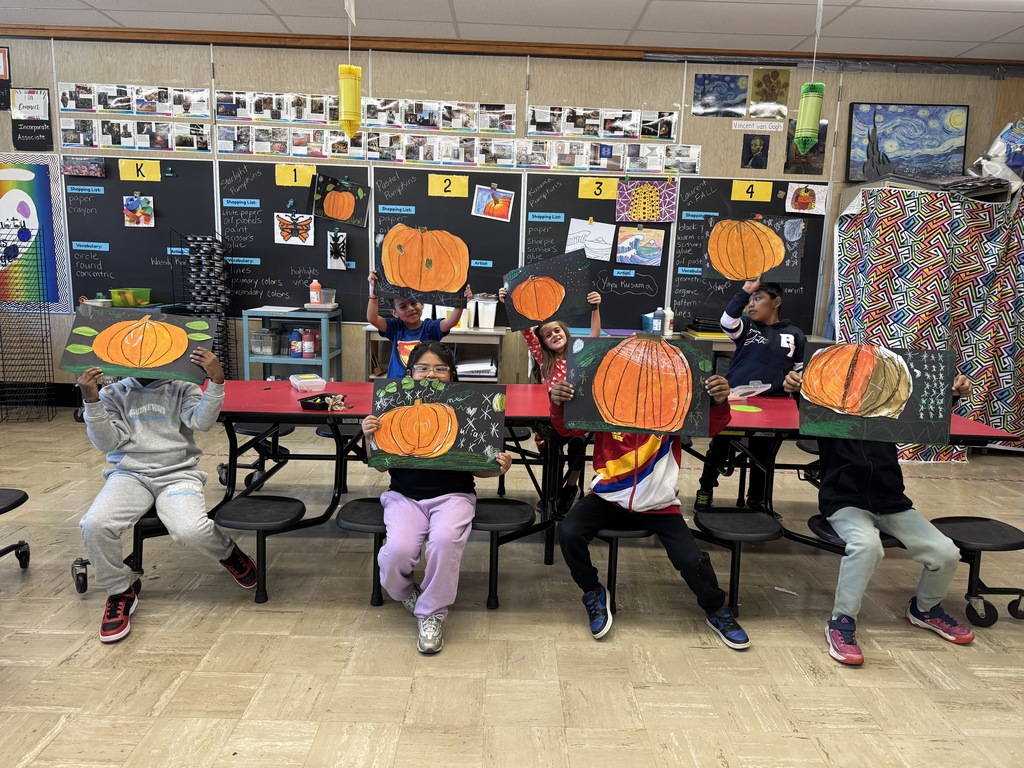 First graders show their pumpkin art.