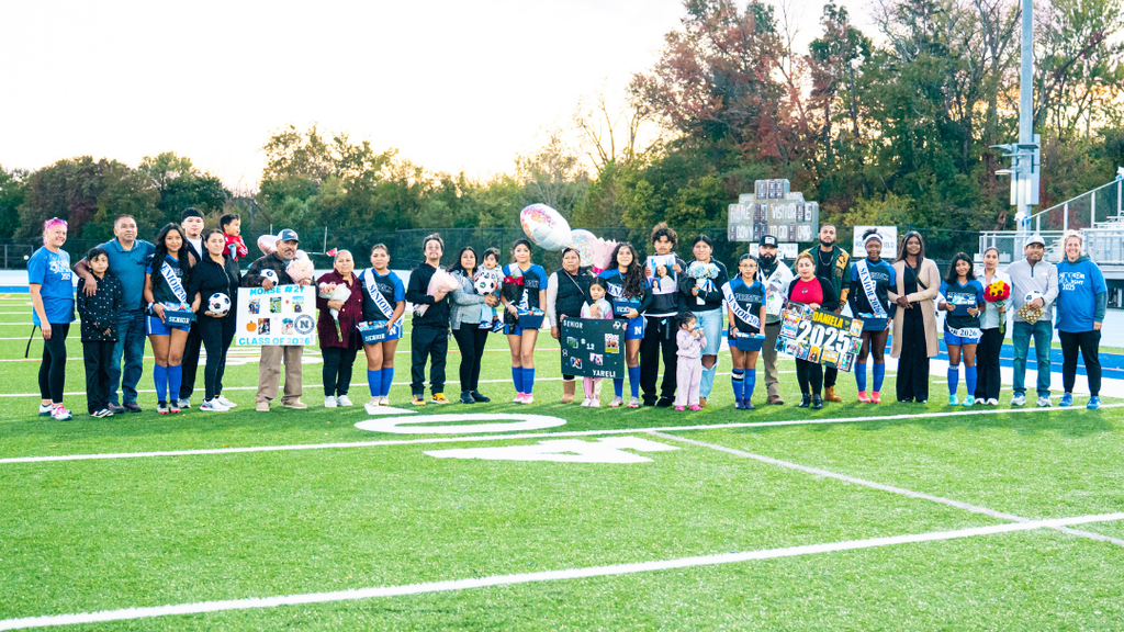 Senior Girls soccer players pose for large group photo with their families and coaches.