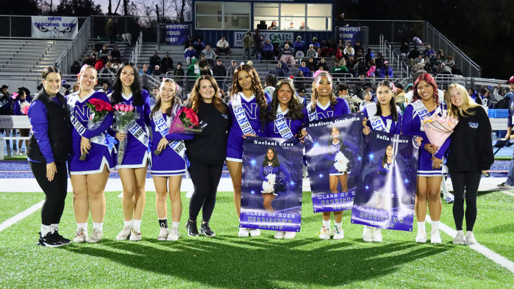 Senior cheerleaders pose for photo with their coaches.