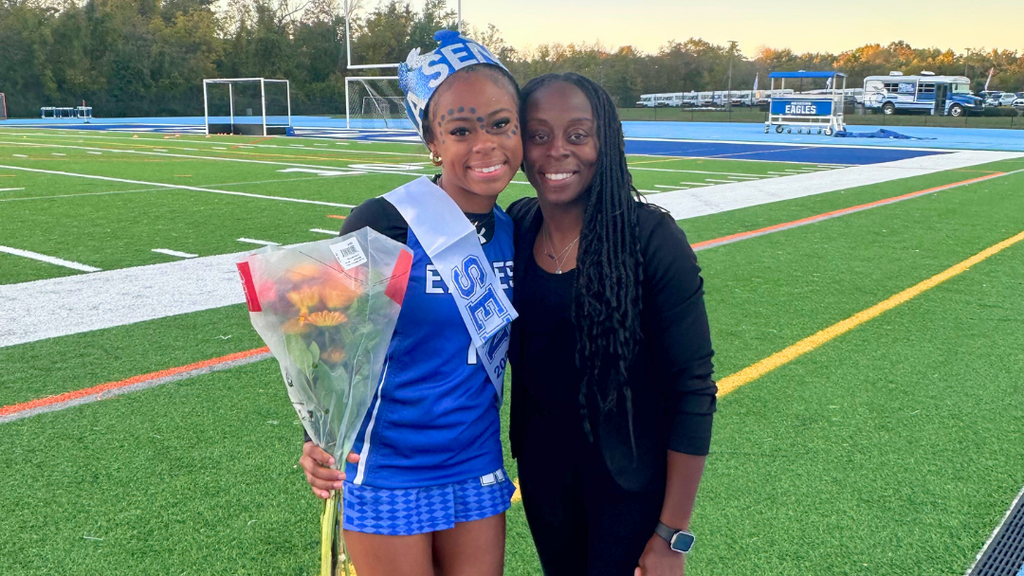 Field hockey senior poses for photo with her mom.