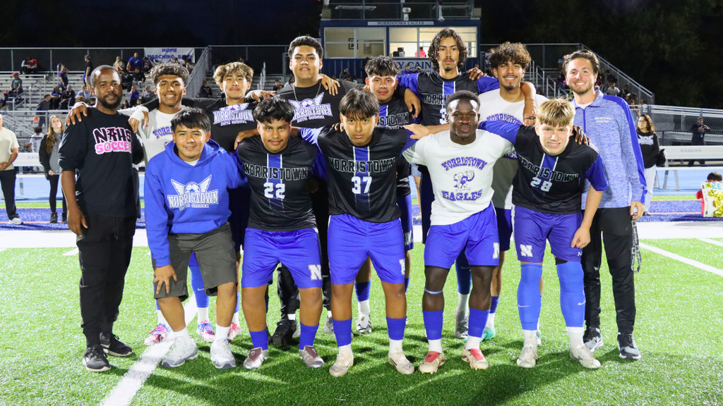 Senior boys soccer players pose for photo with their coaches.