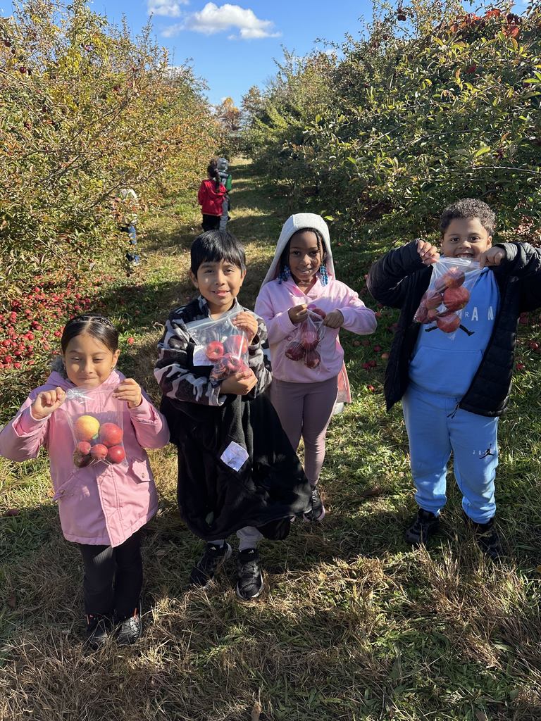 Students hold their bag of apples.