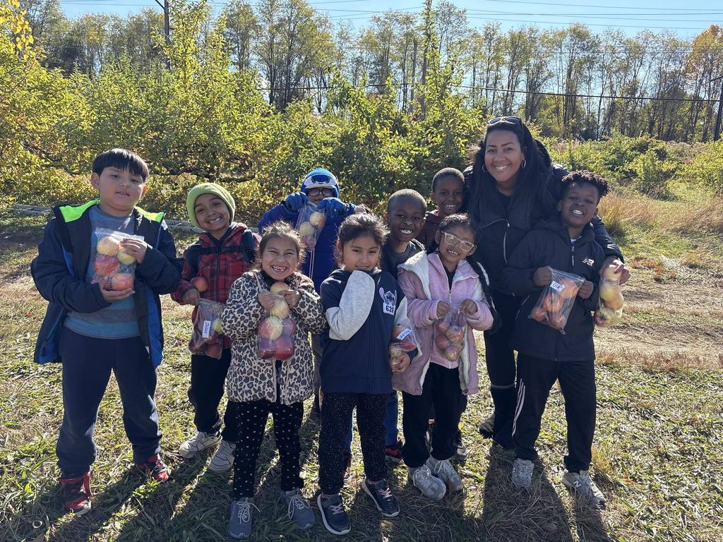 Mrs. White and her students stop for a photo while picking apples.