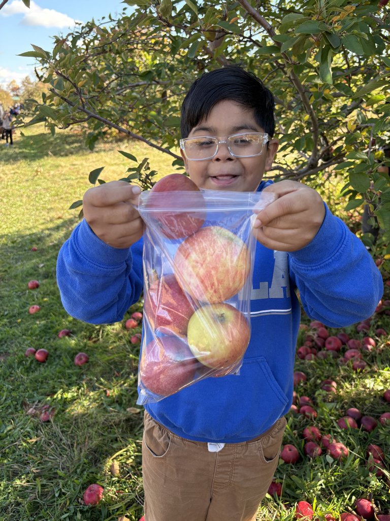 A student holds a bag of apples.