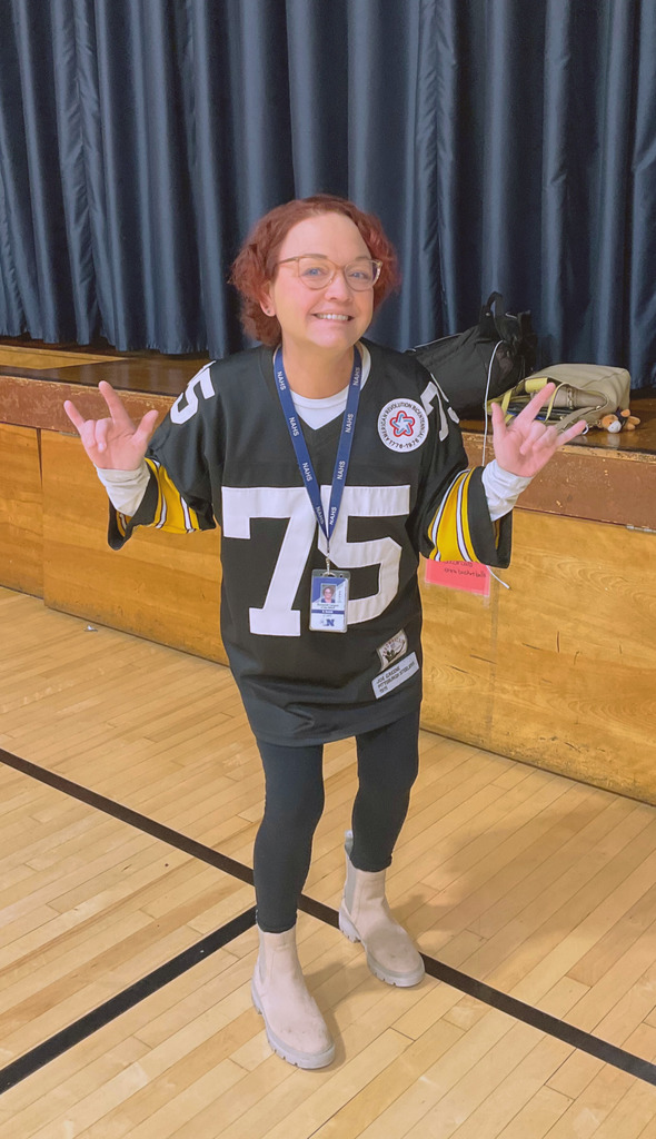The counselor is posing with her Steelers Jersey for spirit day.