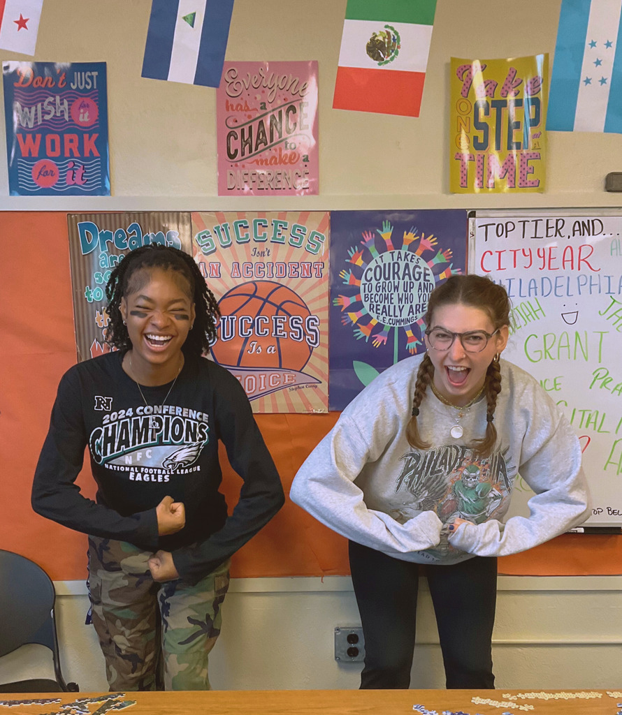 Two city year coaches are posing in the sports gear for spirit day.