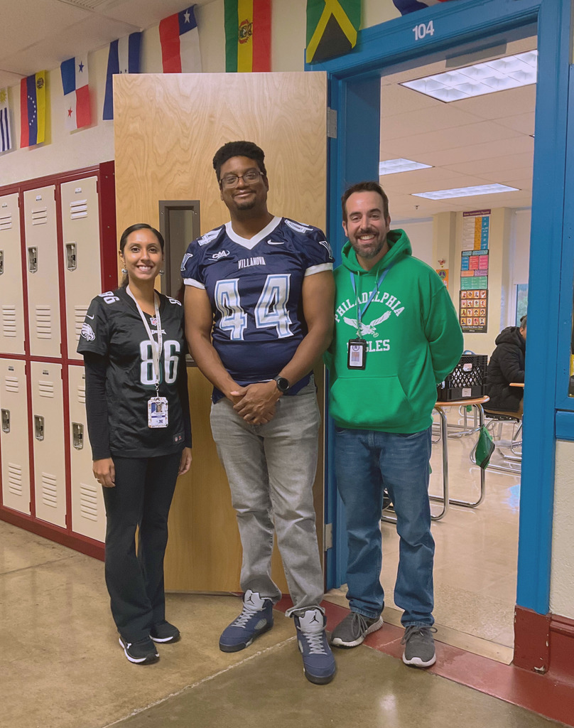Three teachers pose with their jerseys for sports spirit day.