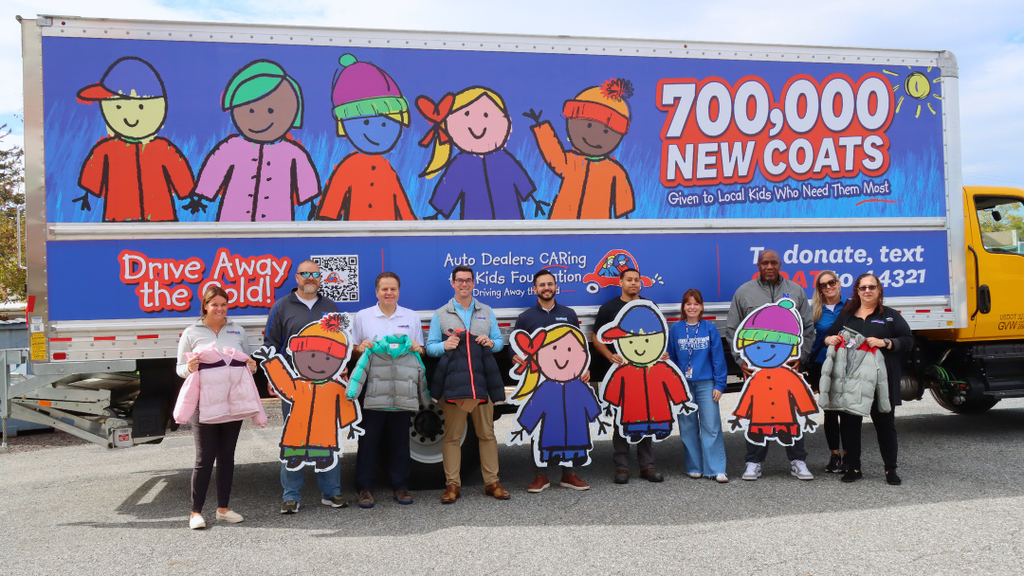 NASD Staff and Conicelli Staff pose for photo with coats and posters in front of truck.