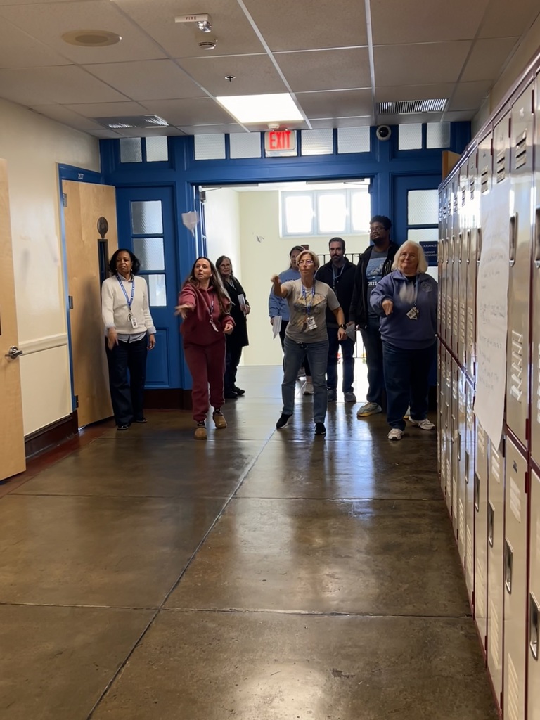 Teaches participate in a brain break activity of throwing paper airplanes