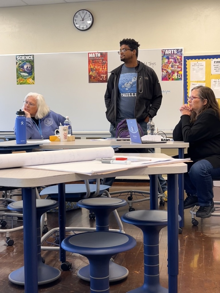 Teachers pay attention to another speaker across the room.