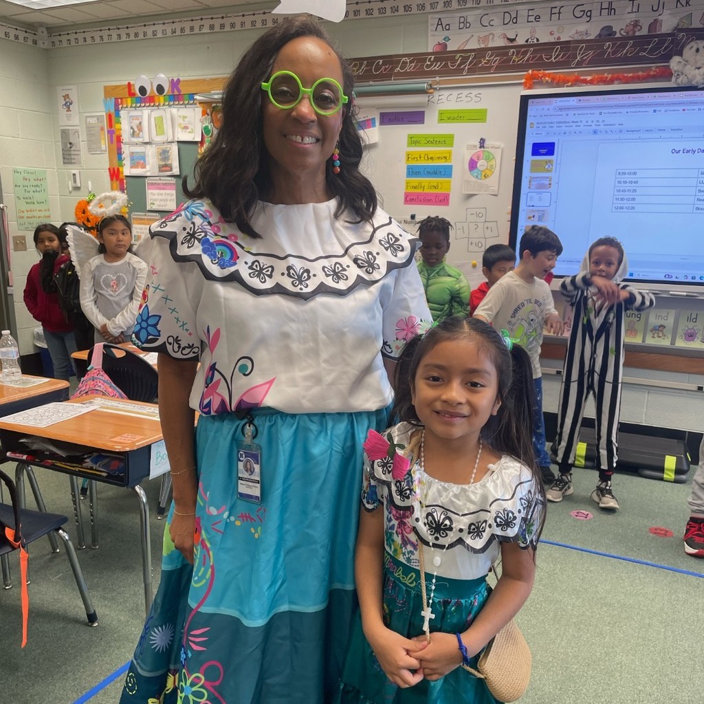 Dr. Kirksey and a student both dressed as Mirabel from the book and movie Encanto.