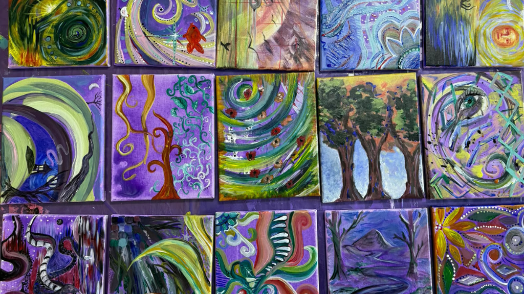 Painted canvases laid flat on table.