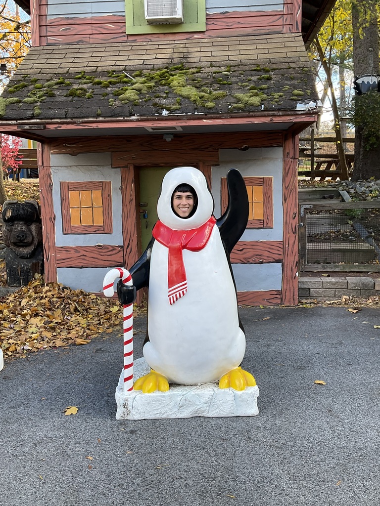 A student put his face in a penguin statue to take a picture