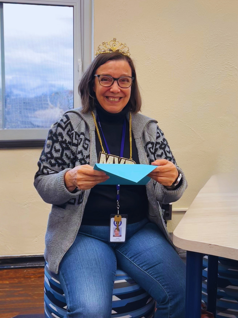 The community liaison is posing with her crown and MVP necklace