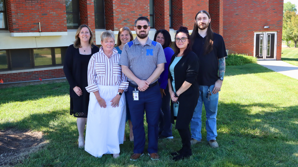 NASD Administration Building Support Staff pose for group photo in front of the building. 