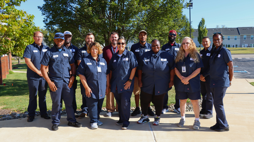 NASD transportation staff pose for group photo outside of the admin building. 