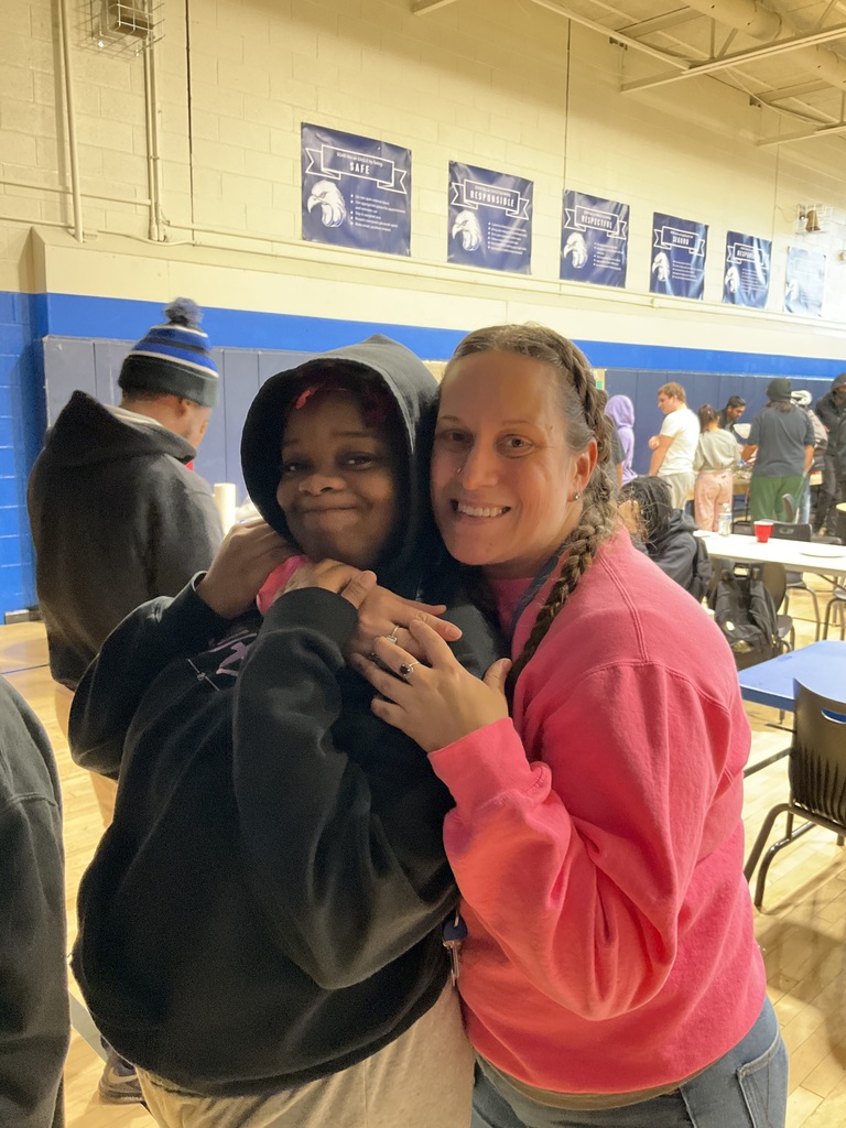 A student and teacher embrace for a picture