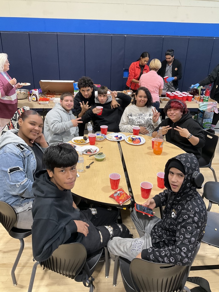 Students sit together and pose for a picture while eating
