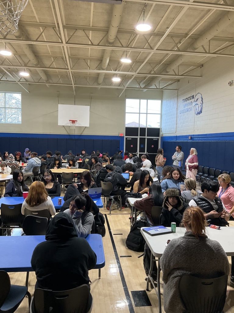 There are many students in the cafeteria participating in Friendsgiving in the cafeteria