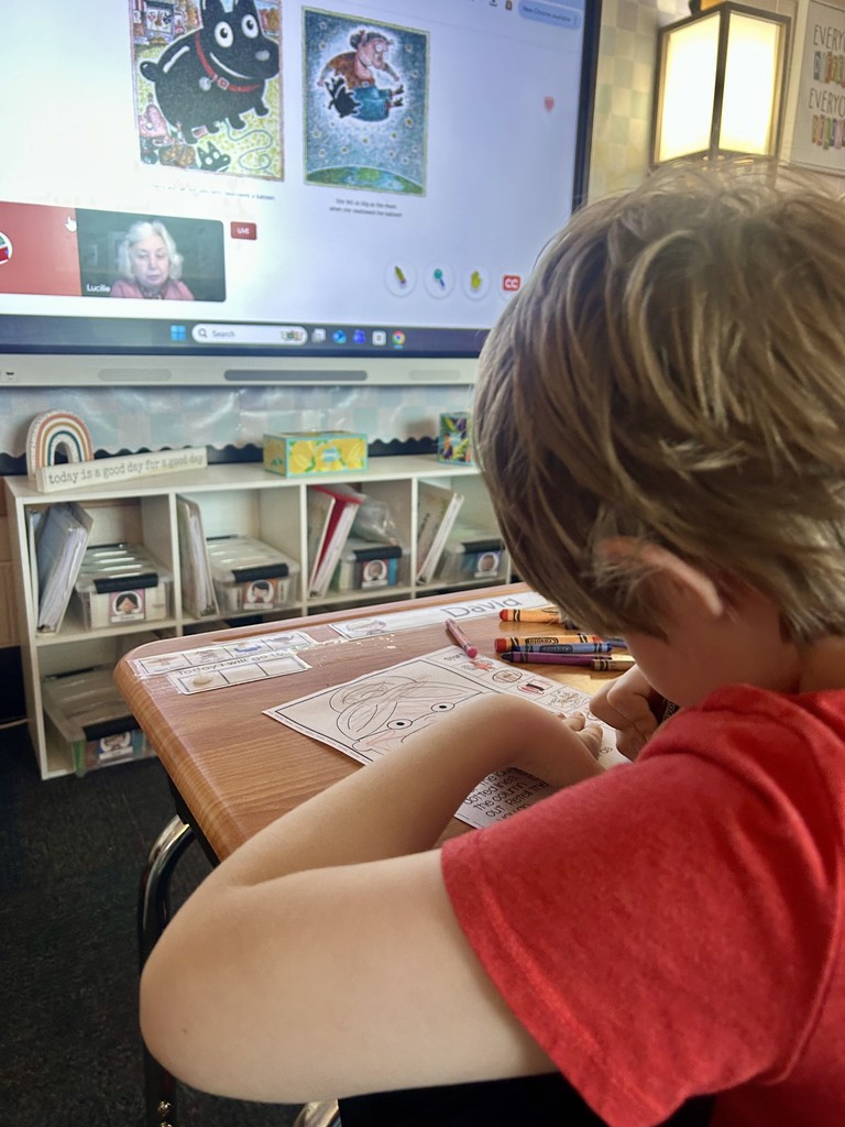 Students listening to the author read her book virtually to the students.