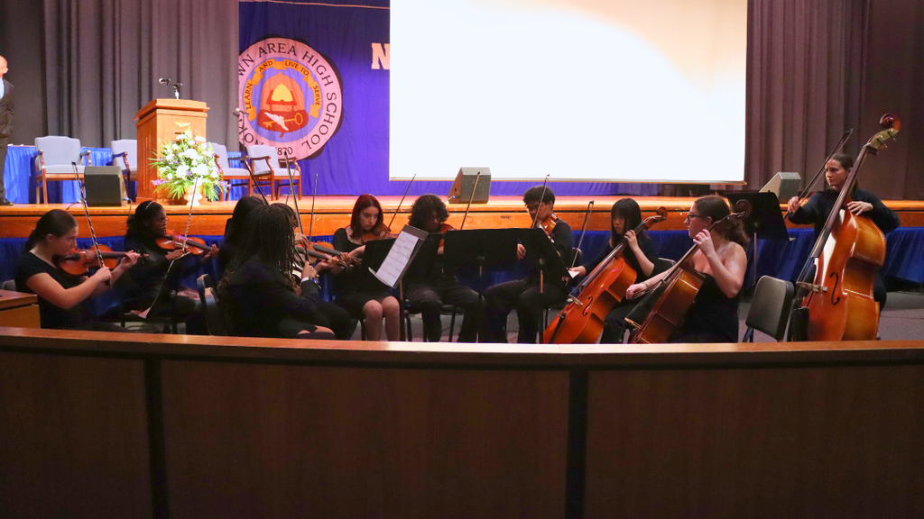 NAHS Honors orchestra performing in front of the stage. 