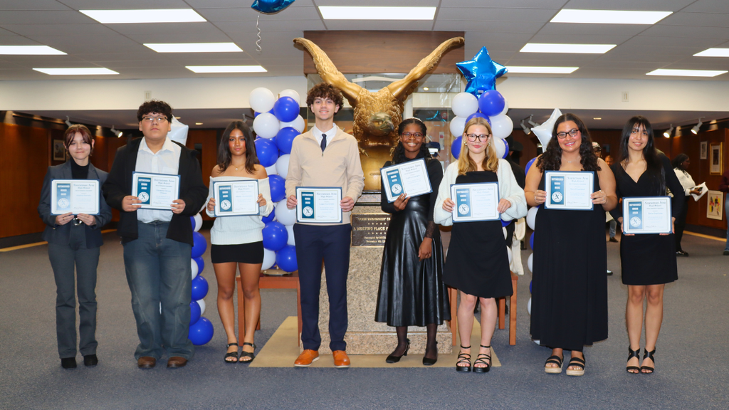 Outstanding student scholars pose for group photo in lobby.  